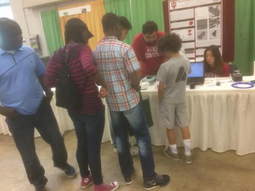Ye group member working with a child at their presentation table